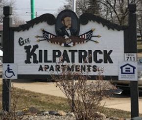 Brown City apartment for rent - A sign for Kilpatrick Apartments is displayed in front of a parking lot.