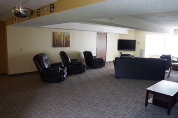 Alma townhouse for rent - A living room with a grey carpet and black furniture.