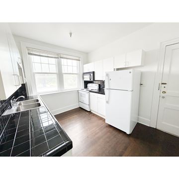 Nashville apartment for rent - A kitchen with a black tiled counter and white appliances.