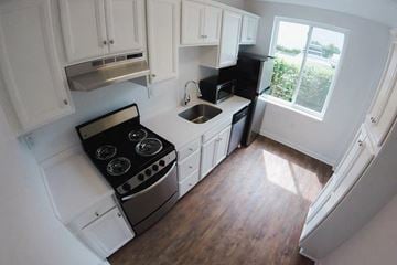 Nashville apartment for rent - A kitchen with white cabinets and a black stove top oven.