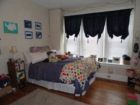 Nashville apartment for rent - a bedroom with a bed and windows with black curtains
