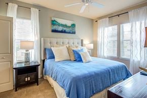 Jacksonville apartment for rent - a bedroom with a large bed and a ceiling fan