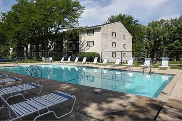 Madison townhouse for rent - a swimming pool with chairs and a building in the background