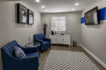 Lounge with navy blue chairs and wall mounted television