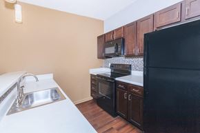 Nashville apartment for rent - a kitchen with black appliances and white counter tops