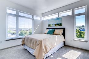 Richmond apartment for rent - a bedroom with a bed and three windows