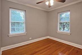 Oak Park apartment for rent - A room with wooden floors and two windows with blinds.