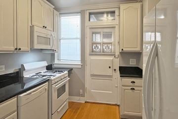 Oak Park apartment for rent - A kitchen with white cabinets and black countertops.