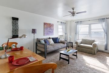Kansas City apartment for rent - a living room with a couch and a table and a ceiling fan