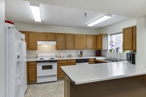 Plymouth apartment for rent - a kitchen with white appliances and wooden cabinets