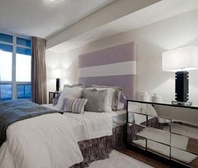 Toronto apartment for rent - A bedroom with a large bed and a large window.