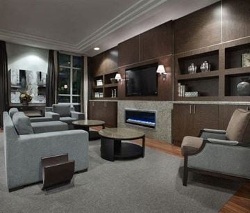 Toronto apartment for rent - A modern living room with a grey sofa set, a coffee table, and a television.