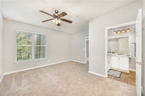 Gainesville apartment for rent - A spacious room with a ceiling fan and carpeted floor.