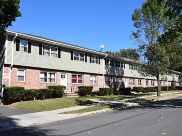 New Haven apartment for rent - A long building with a red door and a green roof.