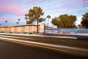 Phoenix apartment for rent - a blurred street in front of a building with palm trees