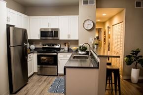 Sacramento apartment for rent - Sacramento California Apartments for Rent - Waterford Cove - Kitchen with Dark Countertops, White Cabinets, Small Breakfast Bar, and Appliances