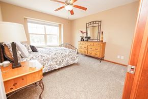West Des Moines townhouse for rent - a bedroom with a bed and a dresser and a ceiling fan