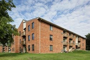 Round Lake apartment for rent - the exterior of a brick apartment building on a cloudy day
