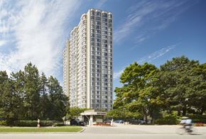 Brampton apartment for rent - a man riding a bike down a street in front of a tall building