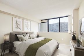Brampton apartment for rent - bedroom with large windows and a bed with white sheets and pillows