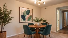 Randallstown apartment for rent - A dining room with a round table and green chairs.