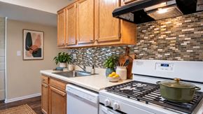 Randallstown apartment for rent - A kitchen with a white stove top oven and wooden cabinets.