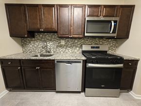 Gwynn Oak apartment for rent - A kitchen with brown cabinets and a granite countertop.