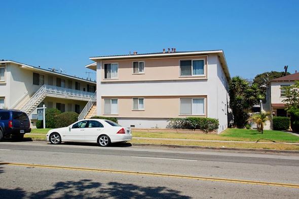 Culver City apartment for rent - A white car is parked on the side of the road in front of a two-story building.