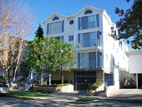 Los Angeles apartment for rent - A white and blue apartment building with a black gate in front.
