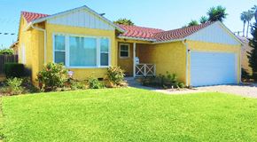 Los Angeles apartment for rent - A yellow house with a red roof and a white garage door.