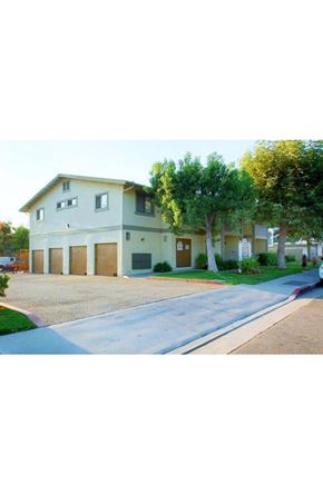 Orange apartment for rent - a large white house with trees in front of it