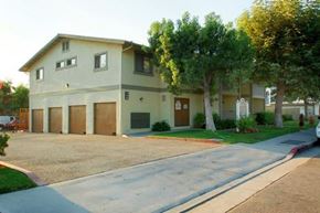 Orange apartment for rent - a white house with a driveway and some trees