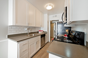 Sherman Oaks apartment for rent - a kitchen with white cabinets and black appliances and a sink