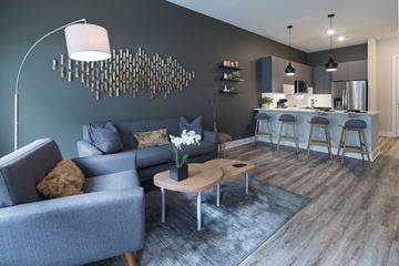 Pittsburgh apartment for rent - A modern living room with a grey couch and a wooden coffee table.