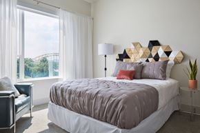 Pittsburgh apartment for rent - A bedroom with a large bed and a view of a bridge outside the window.