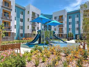 San Jose apartment for rent - A playground with a blue slide in front of a white and blue apartment building.