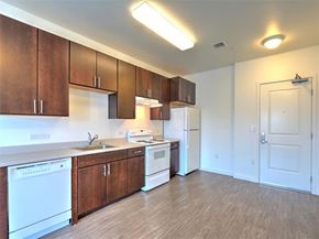 San Jose apartment for rent - A kitchen with white appliances and wooden cabinets.