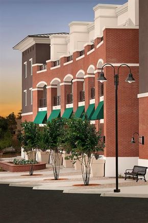 San Luis Obispo apartment for rent - a red brick building with green awnings and a bench