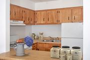 Bloomington apartment for rent - a kitchen with wooden cabinets and a counter with mugs on it