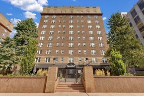 Denver apartment for rent - a large brick building with stairs and a gate in front of it