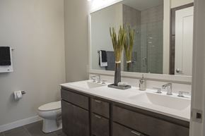 Minneapolis apartment for rent - A bathroom with a toilet, sink, and mirror.