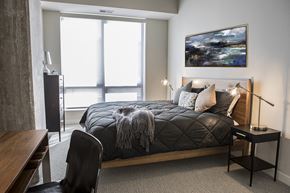 Minneapolis apartment for rent - A bedroom with a large bed and a painting on the wall.