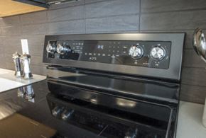Minneapolis apartment for rent - A modern black oven with a digital control panel is installed in a kitchen.