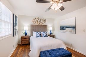 Huntsville triplex for rent - A bedroom with a large bed and a ceiling fan.
