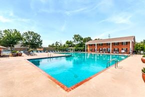 Huntsville triplex for rent - A large outdoor swimming pool with a red border and a building in the background.
