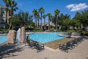 Stafford apartment for rent - A pool with a waterfall and lounge chairs.