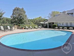 Flowood apartment for rent - a pool with chairs and a house in the background