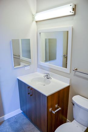 Lowell apartment for rent - A bathroom with a sink, mirror, and toilet.