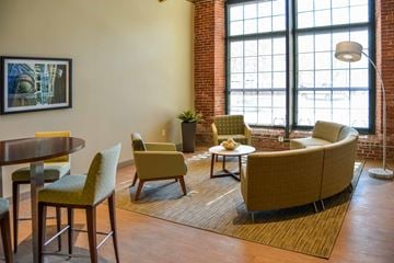Lowell apartment for rent - A living room with a yellow chair and a brown couch.