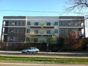 Rochester apartment for rent - a car driving down a street in front of an apartment building